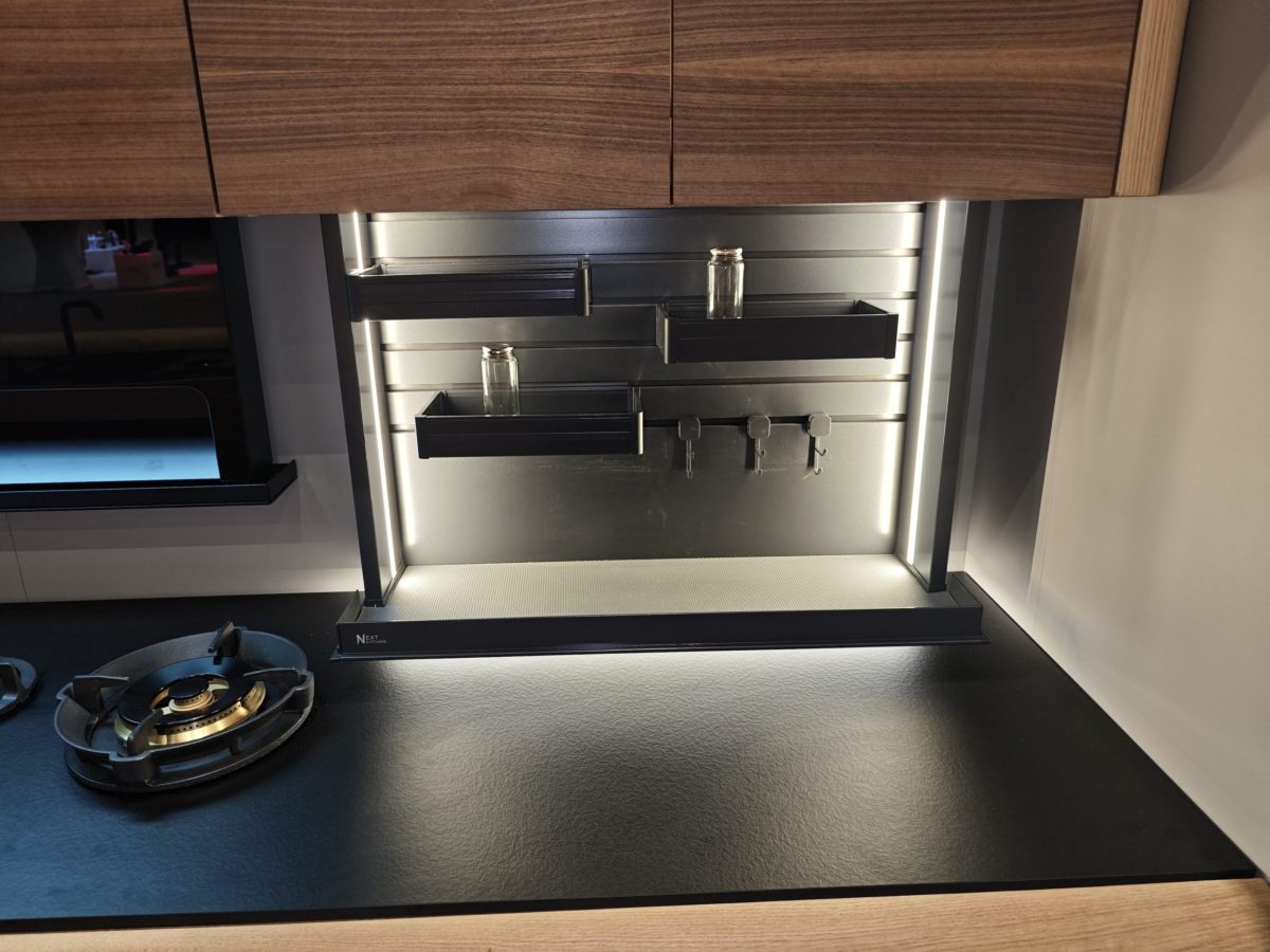 Close-up of integrated dark appliance inside a wood cabinet wall.
