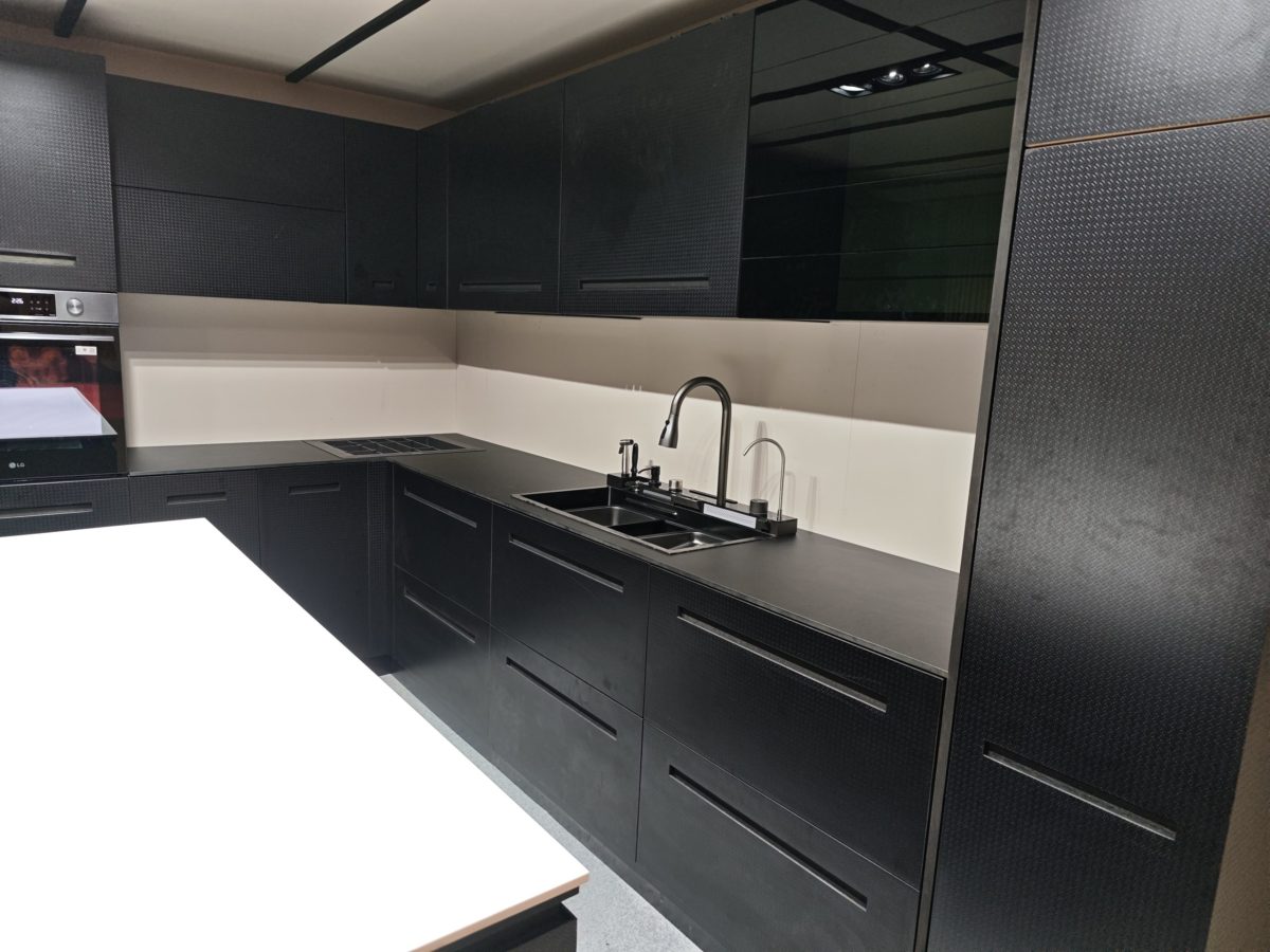 Close view of a wood island corner with integrated black sink.