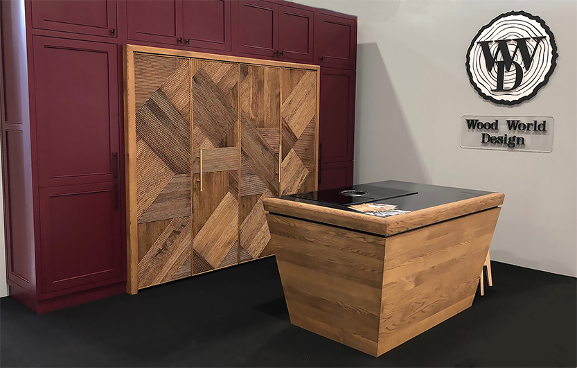 Dark red exhibition wall with diagonal wood door panel and small island.