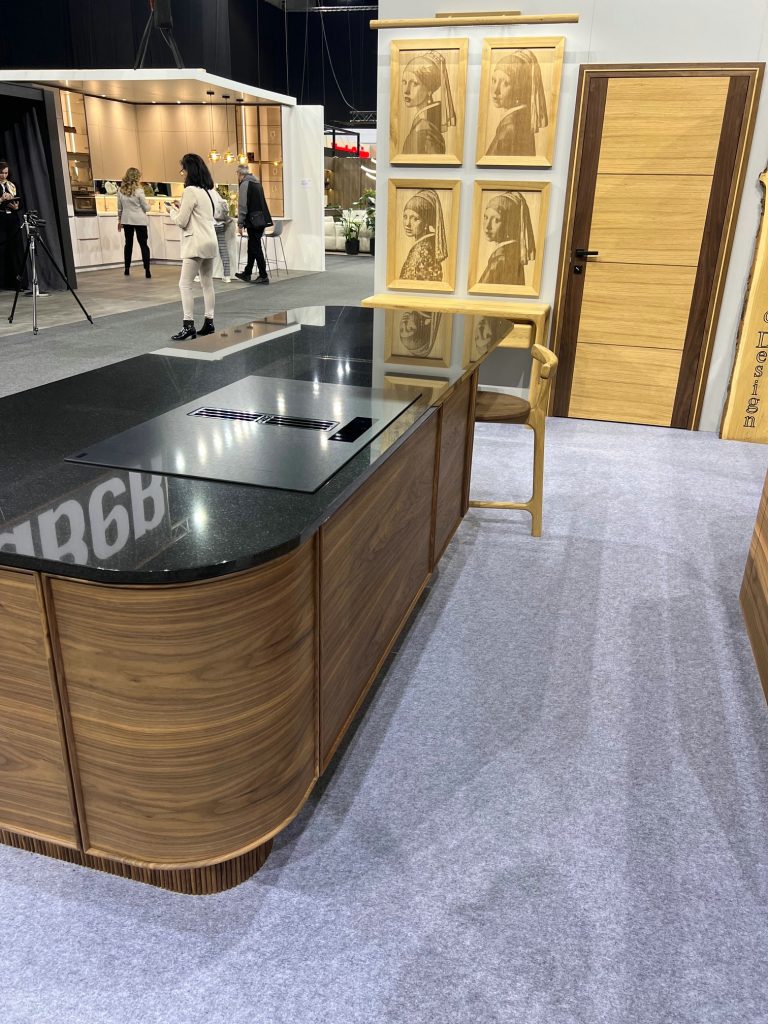 End view of rounded wood island with black stone top.