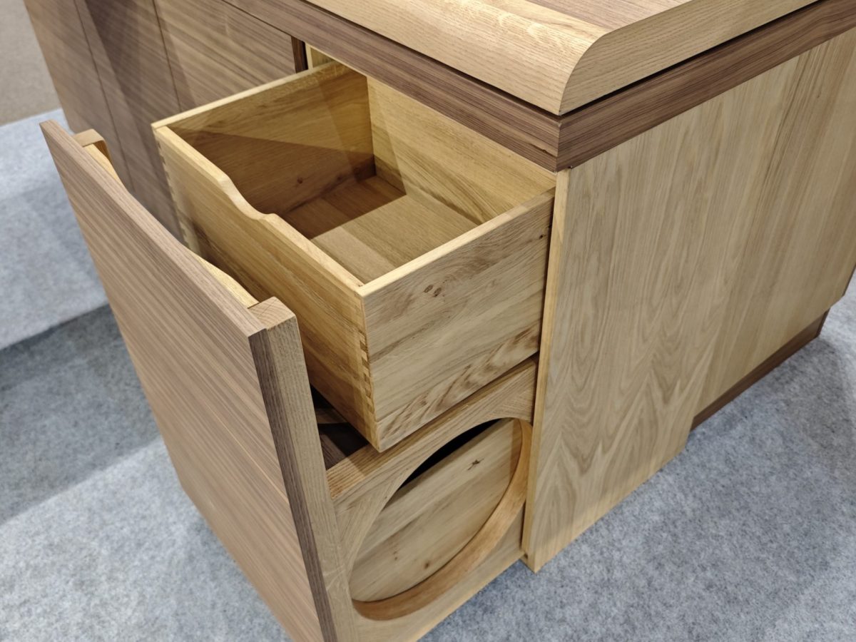 Rounded wood corner with open drawer and circular cutout detail.