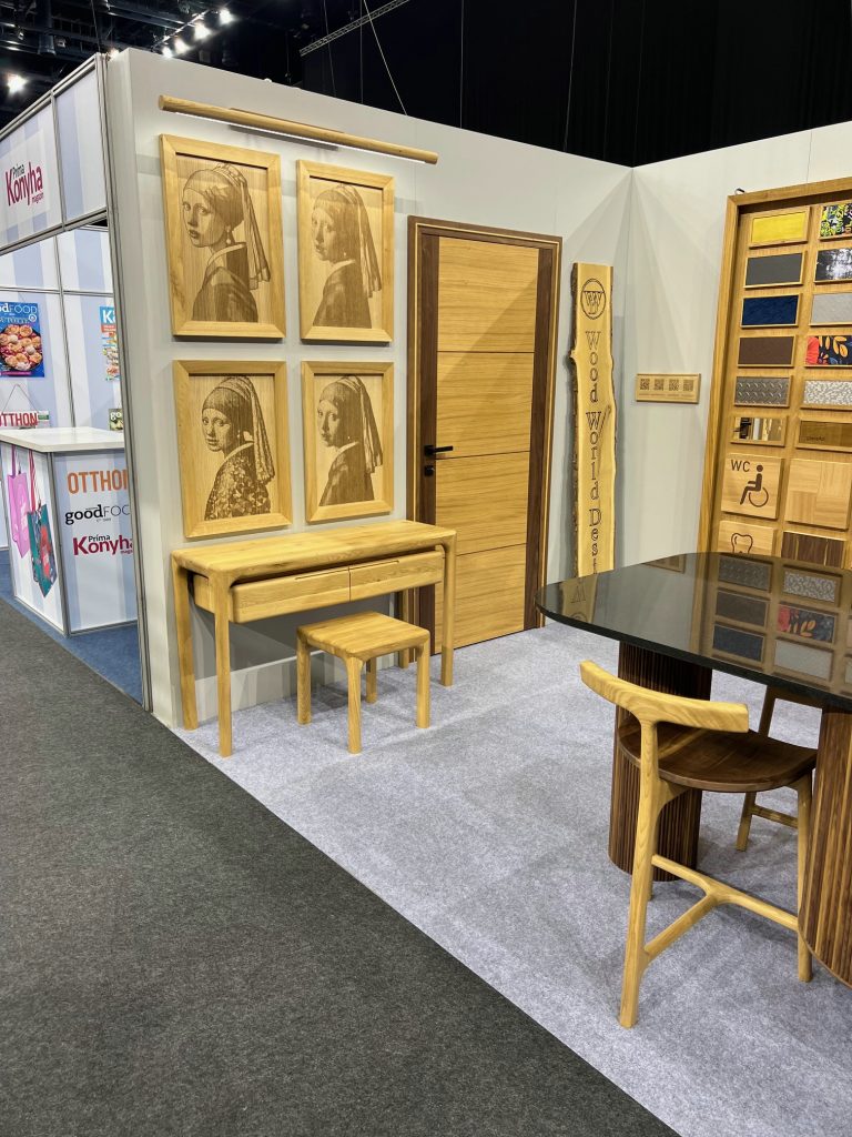 Tall framed wood cabinet samples and a chair on a carpeted stand.
