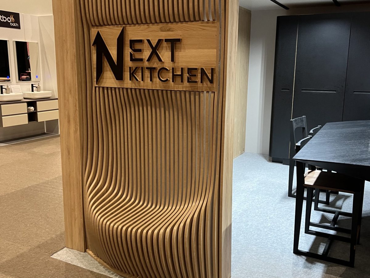 Tall ribbed wood display column with next kitchen lettering.