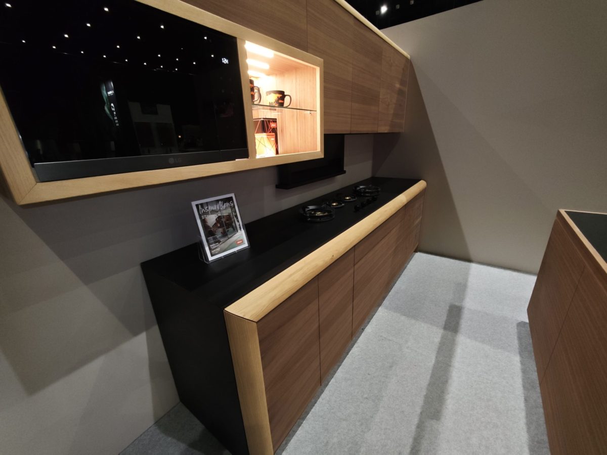 Wall unit with dark screen, lit shelf and wood base cabinet.