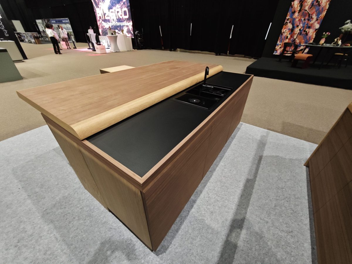 Wood island with deep black inset top and open drawer.