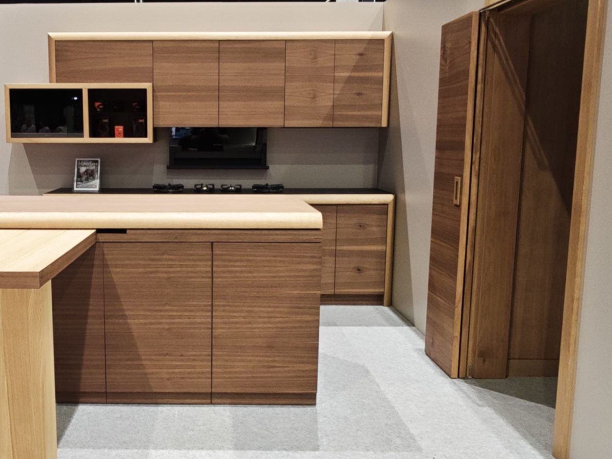 Wood wall cabinet and matching tall storage beside an open floor area.