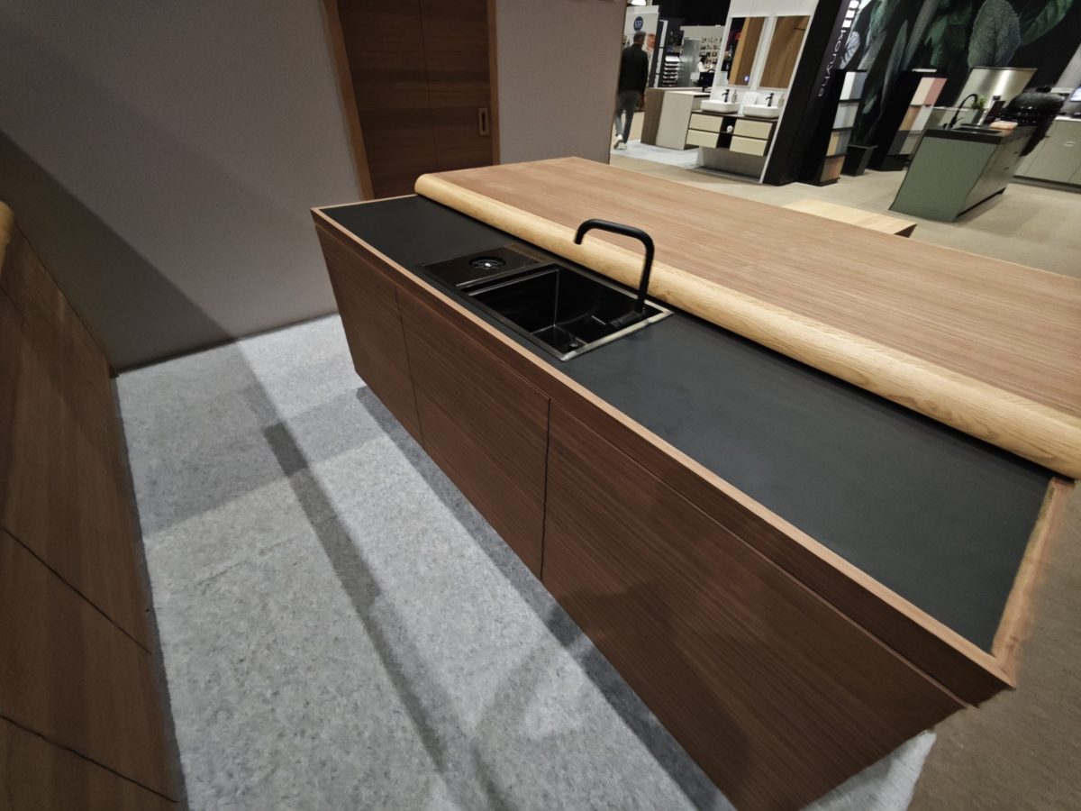Wood worktop edge and black sink seen from above.