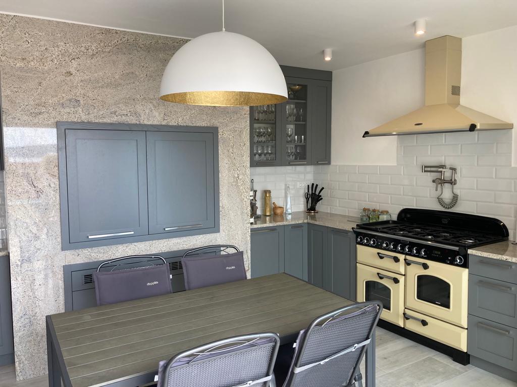 Gray kitchen with black island and cream range.