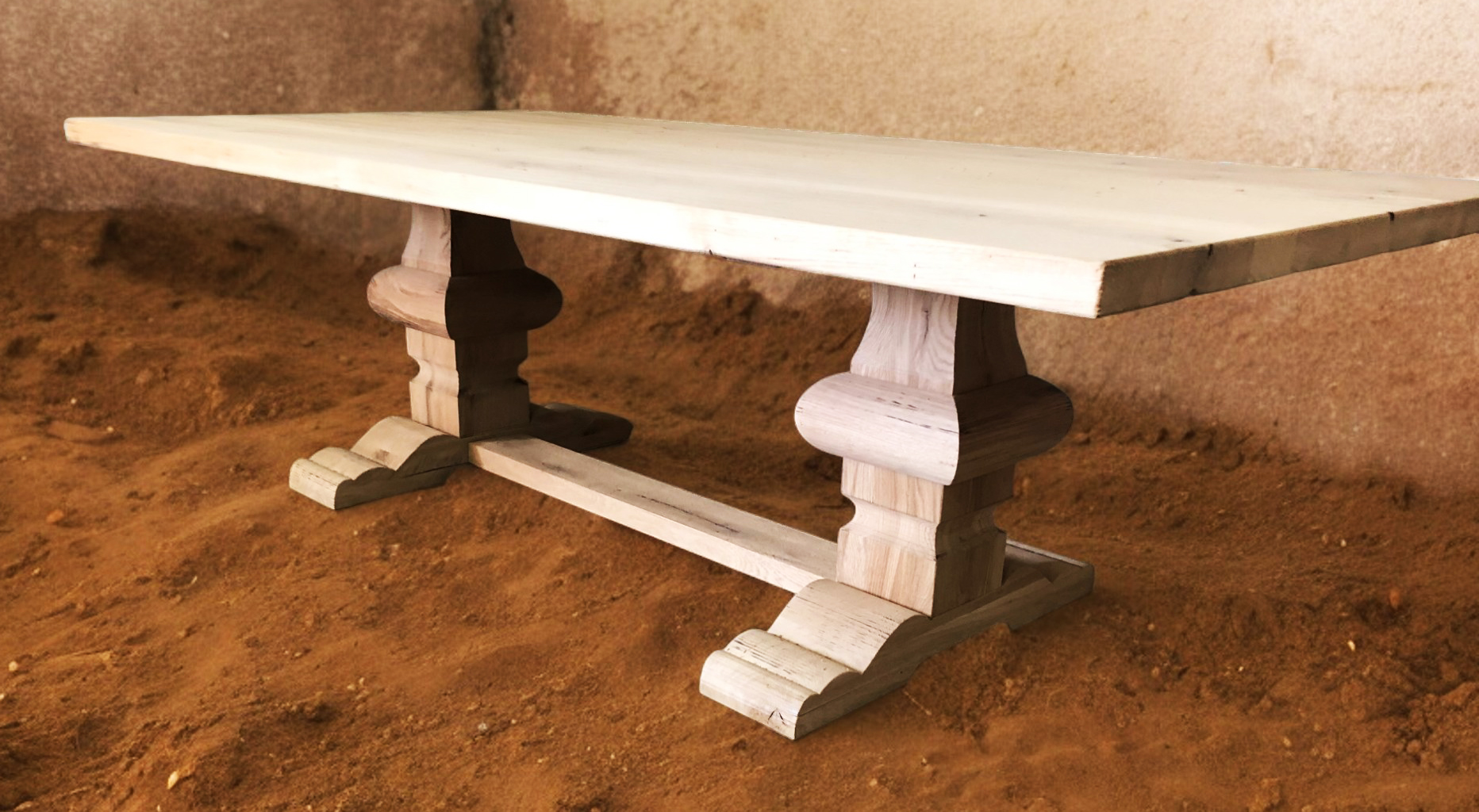 Light tabletop with white turned pedestal legs in a brown-floored room.