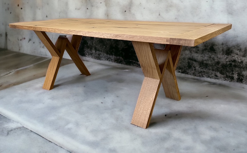 Natural wood tabletop with sharply angled triangular legs.