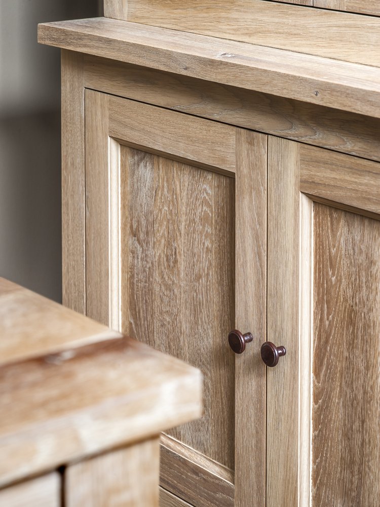Natural wood cabinet door with dark knob.