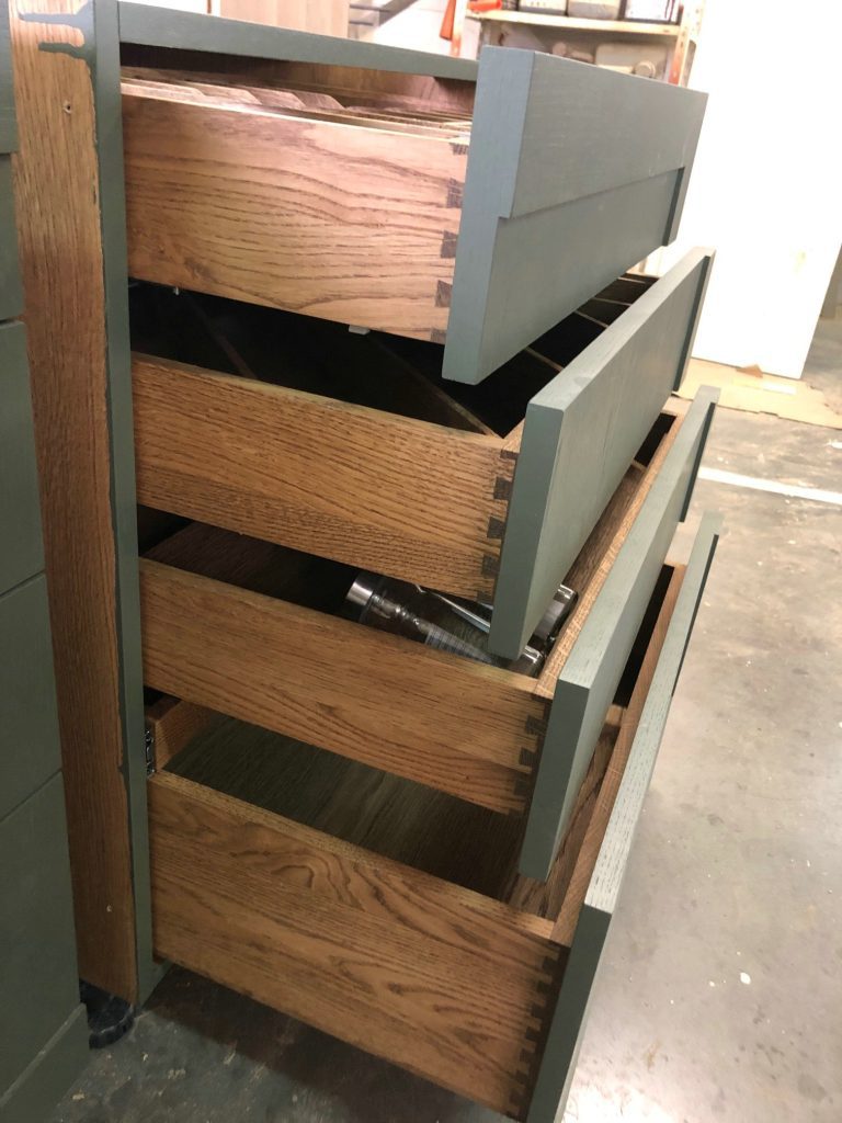 Open cabinet drawers with slatted wooden fronts and visible metal runners.
