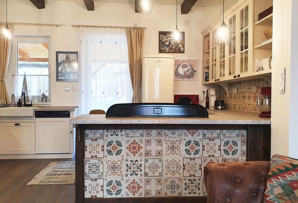 Cream kitchen with a patterned tile island face and open shelving.