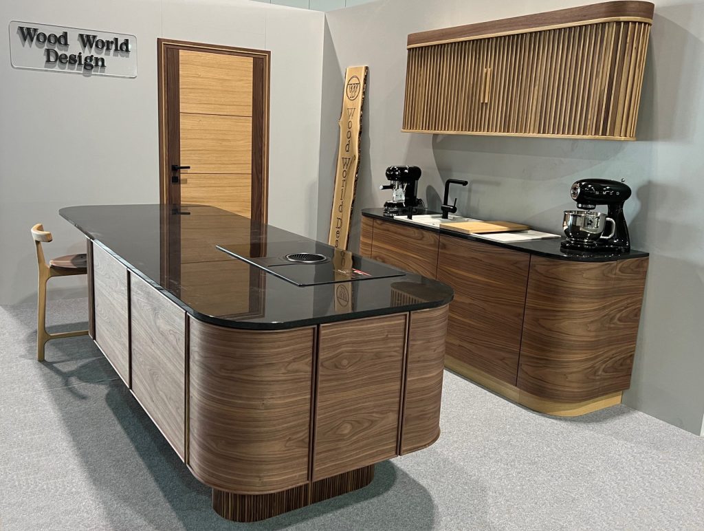 Rounded wood-front kitchen and curved island photographed from the front.