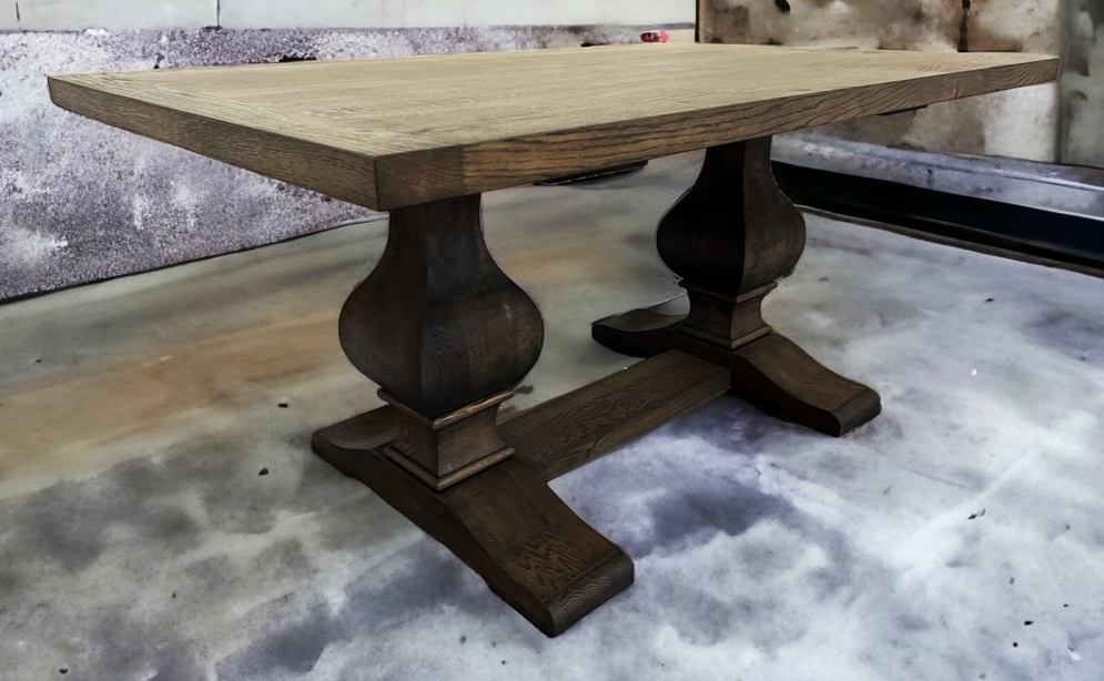 Rustic tabletop on two dark turned pedestal supports.