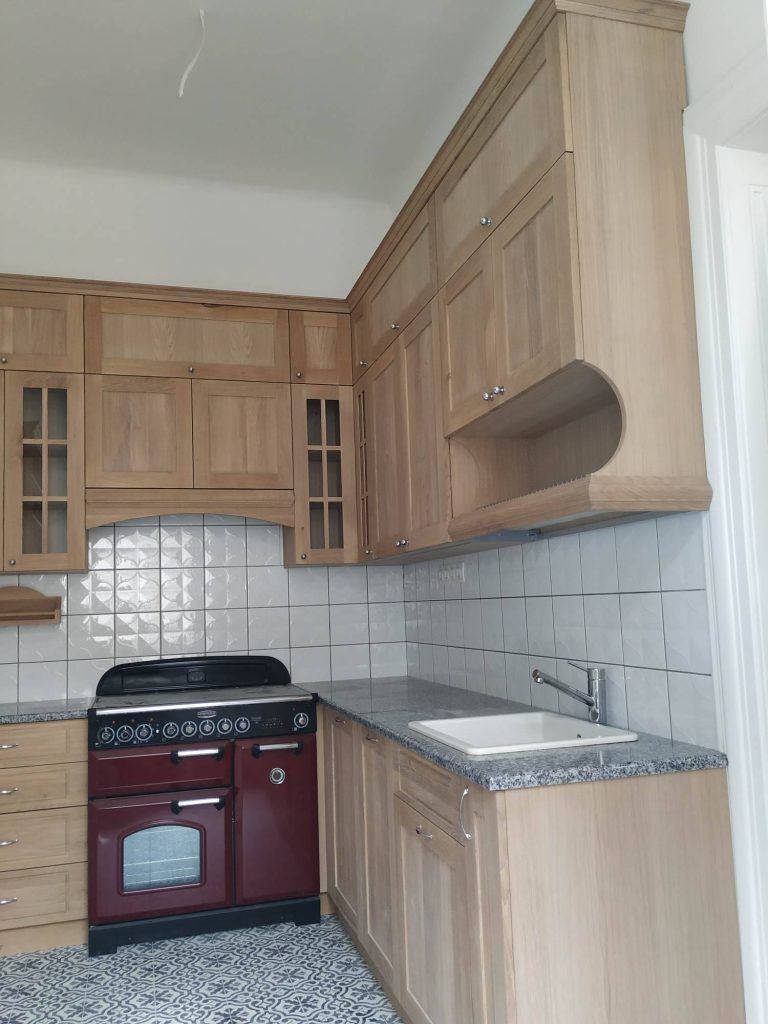 Small wood kitchen with dark red range.