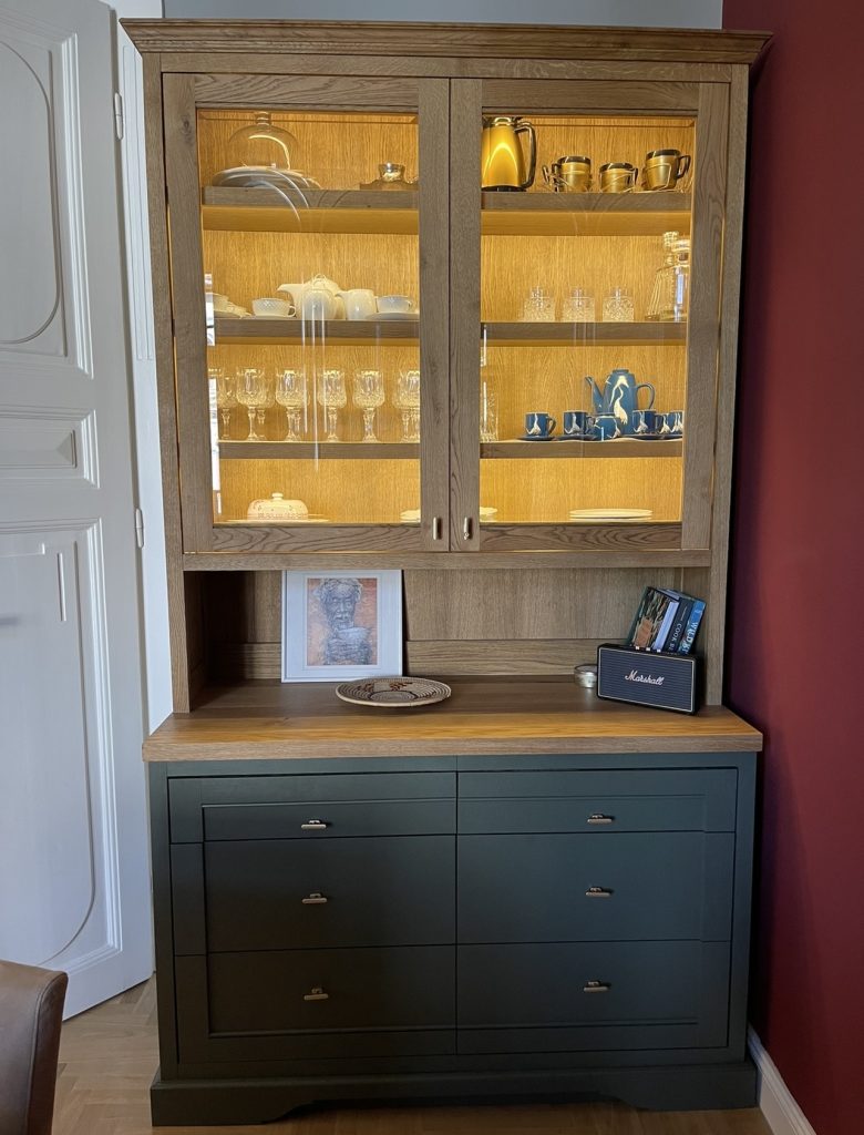 Tall dark glass-front cabinet with dishes.