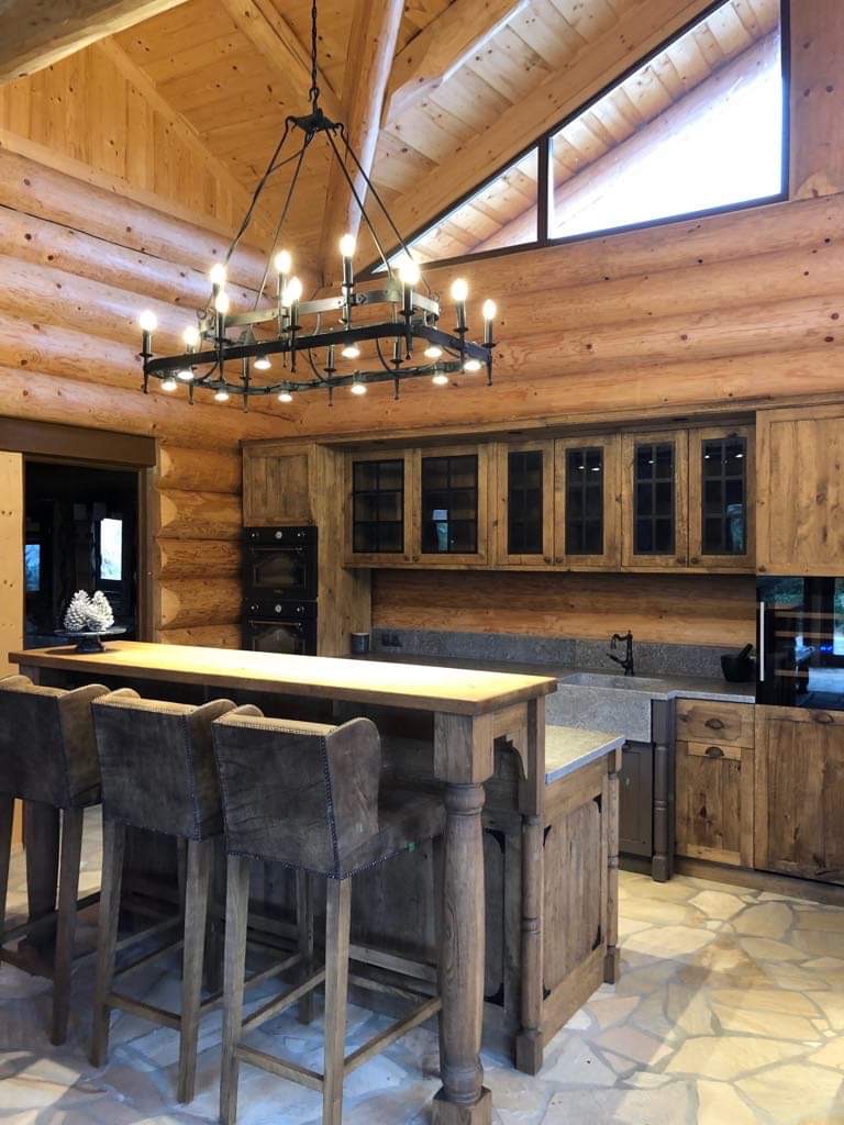 Warm timber kitchen with exposed ceiling beams, island and bar stools.