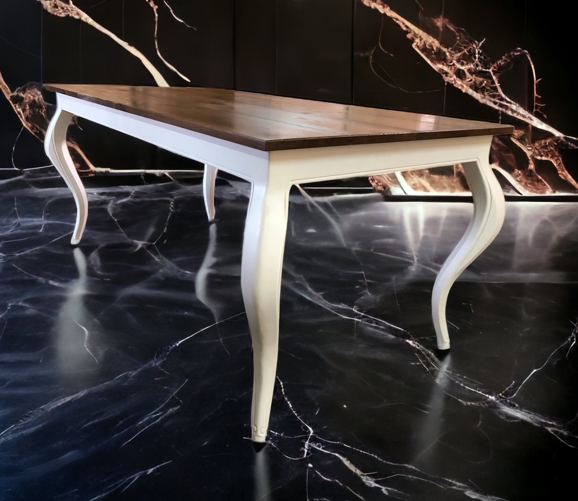 White-edged tabletop with elegant curved white legs against a dark wall.