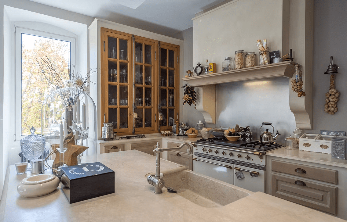 White kitchen with blue-gray range and window.
