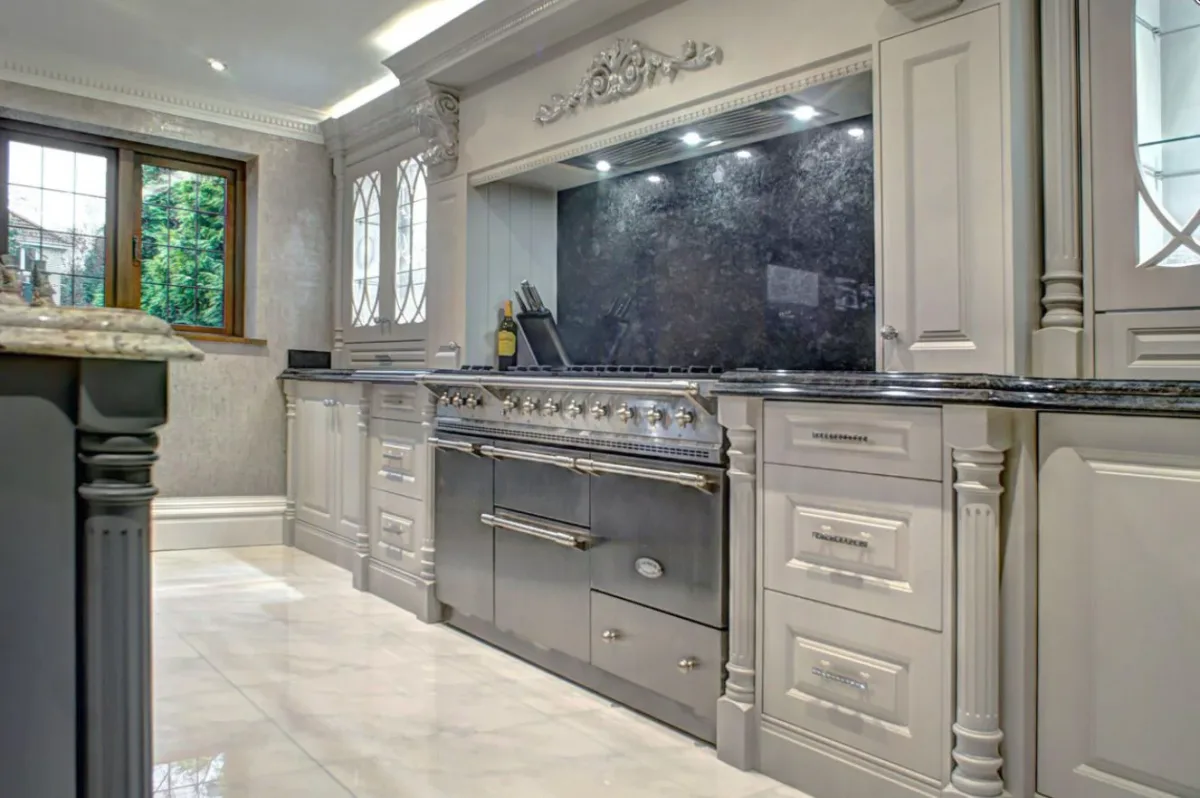 Gray kitchen with glossy dark backsplash.