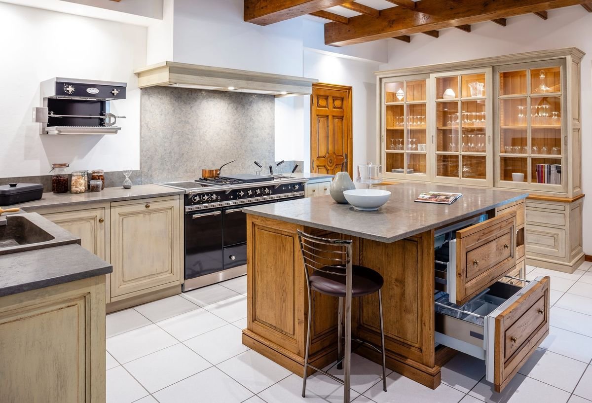 White kitchen with gray island and glass fronts.