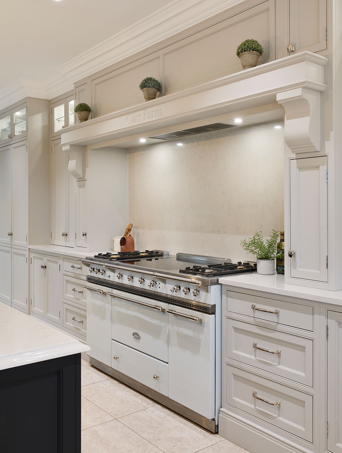 White kitchen with gray island and range.