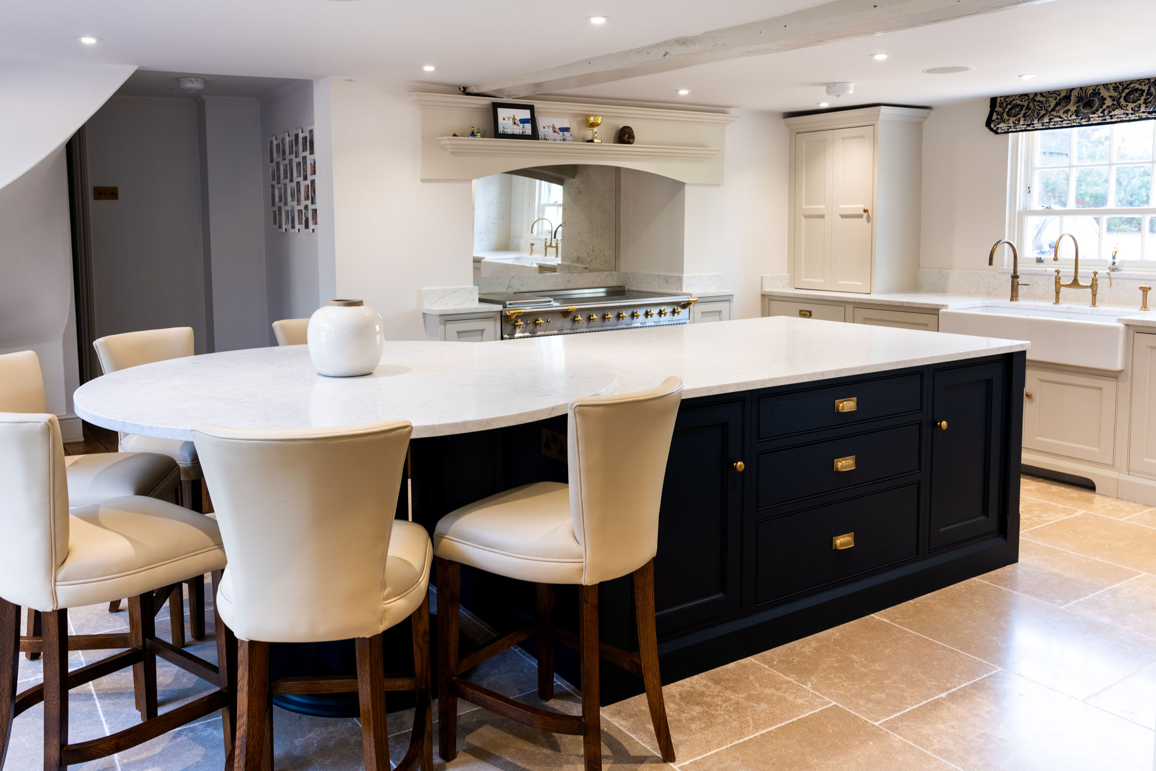 White kitchen with marble backsplash and hood.