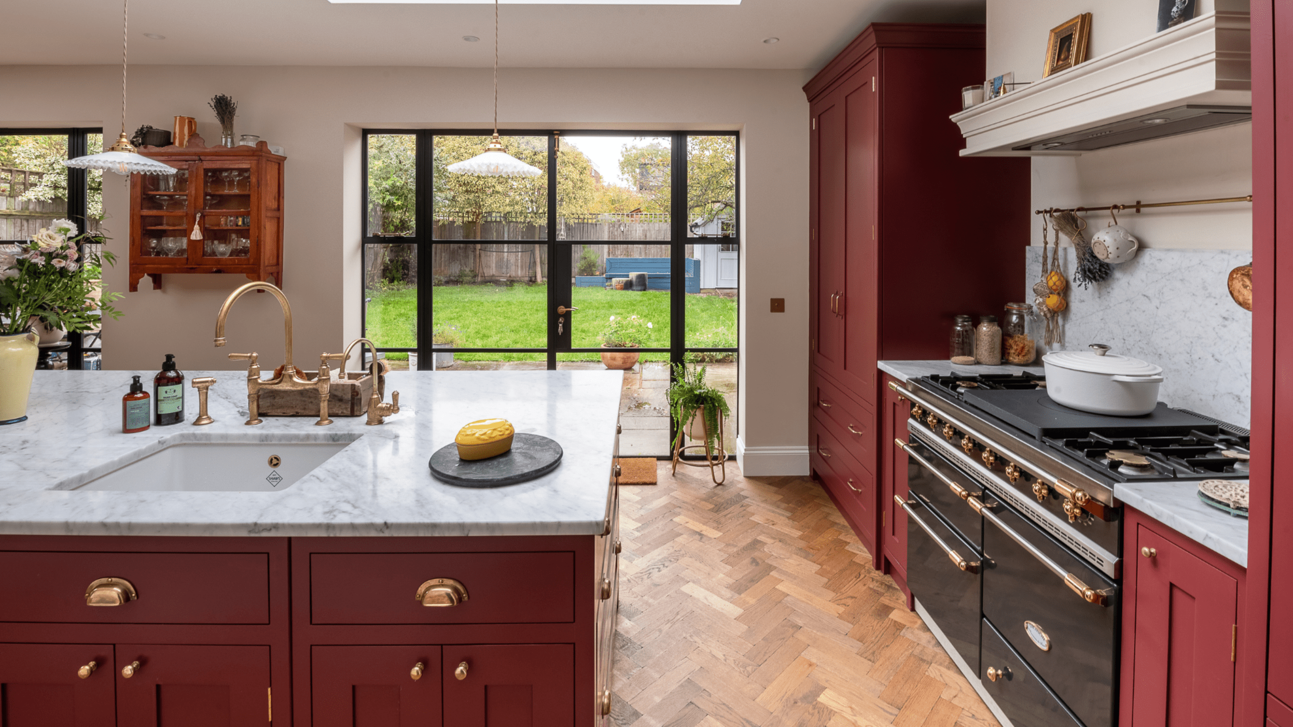White kitchen with pale island and glass doors.