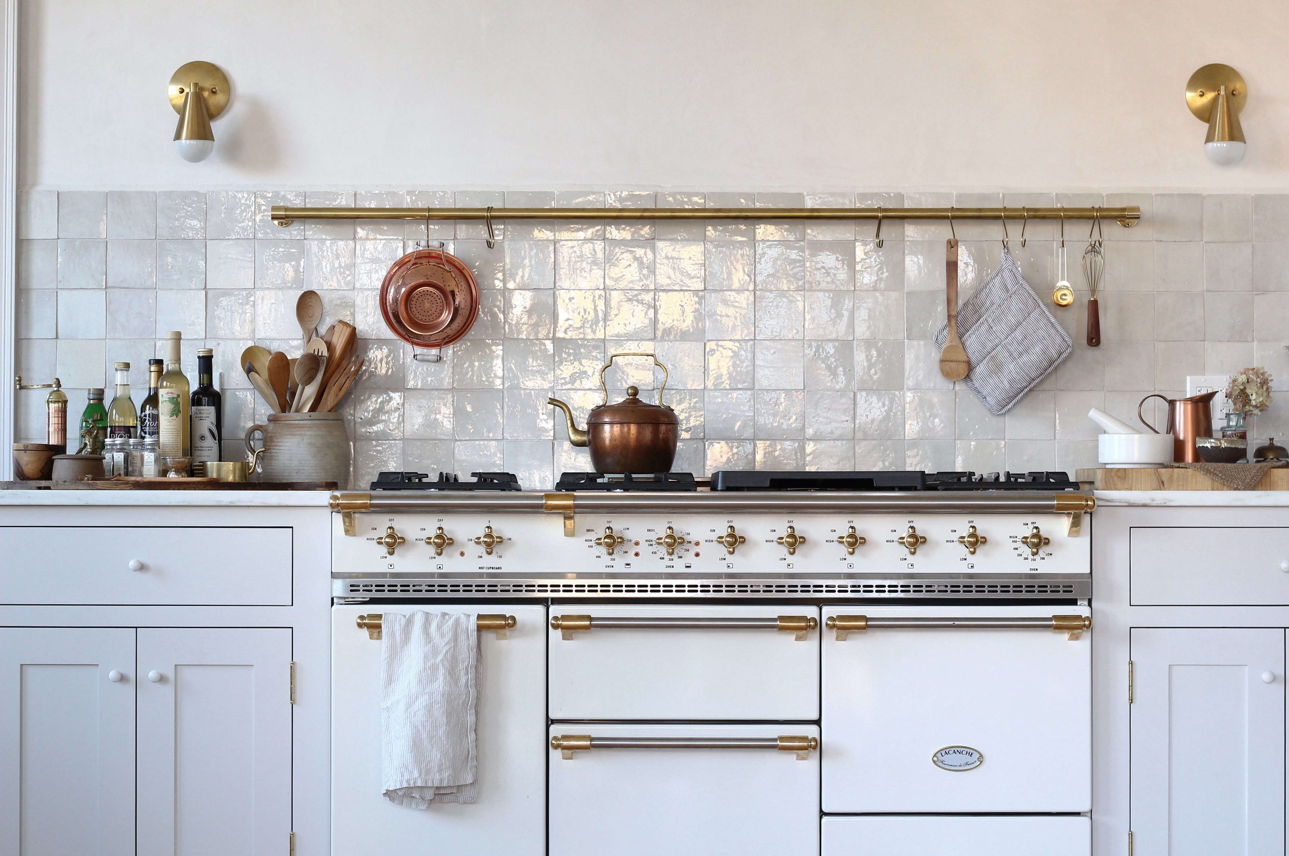 White kitchen with wide hood surround.