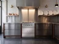 White tiled kitchen with black range.
