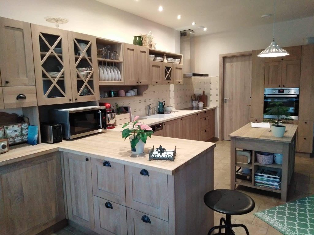 Wood and cream kitchen with island, open shelves and pendant lights.