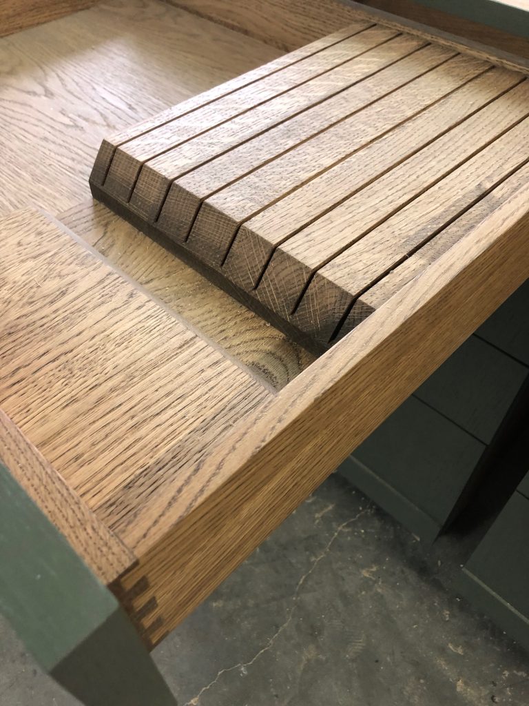 Open cabinet door with pull-out shelf.
