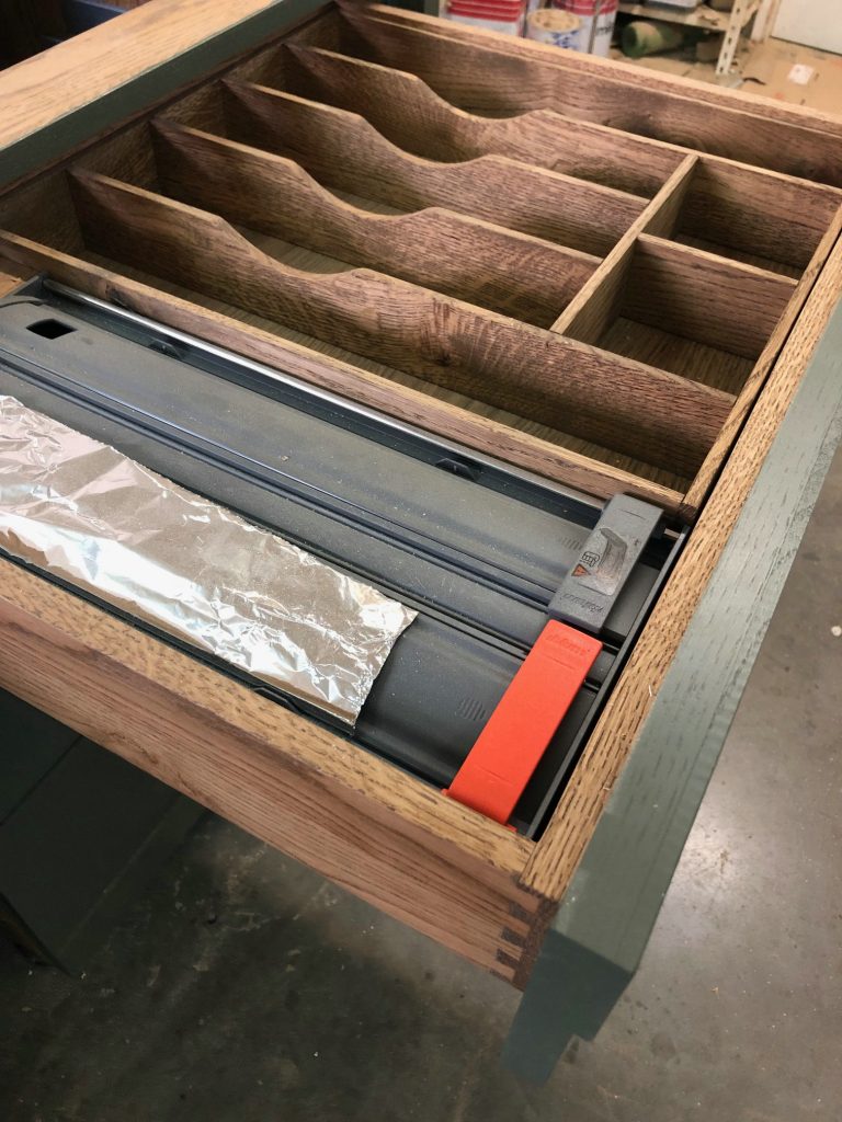 Wood drawer with long angled compartments.