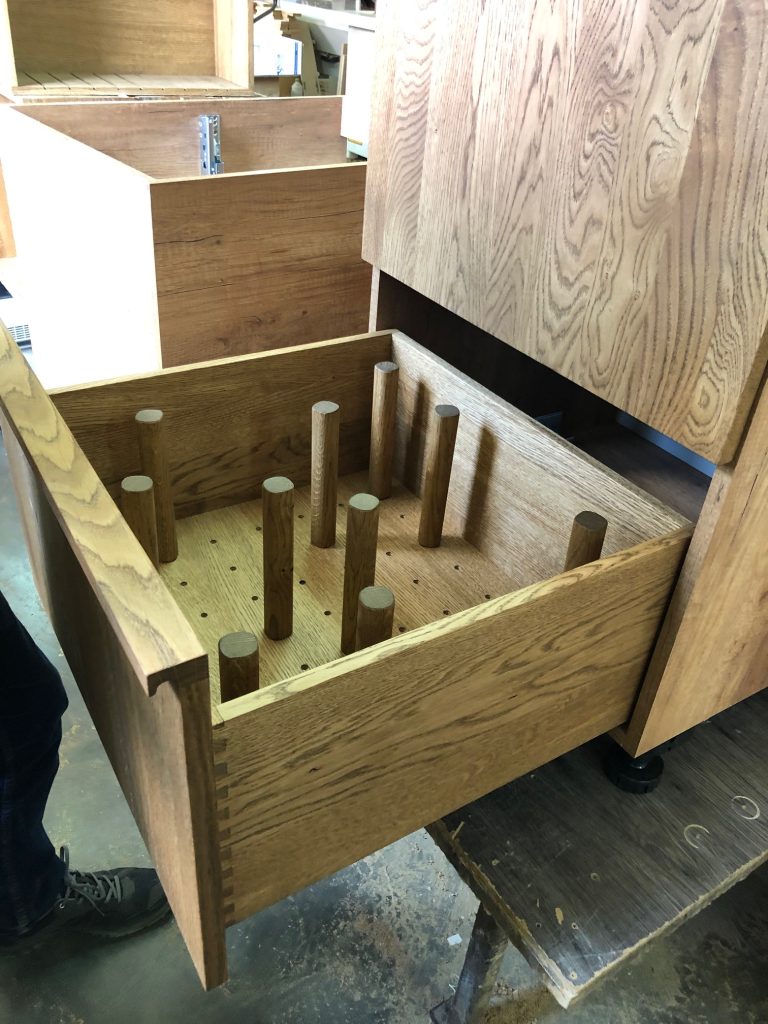 Open wood drawer with stepped compartments.