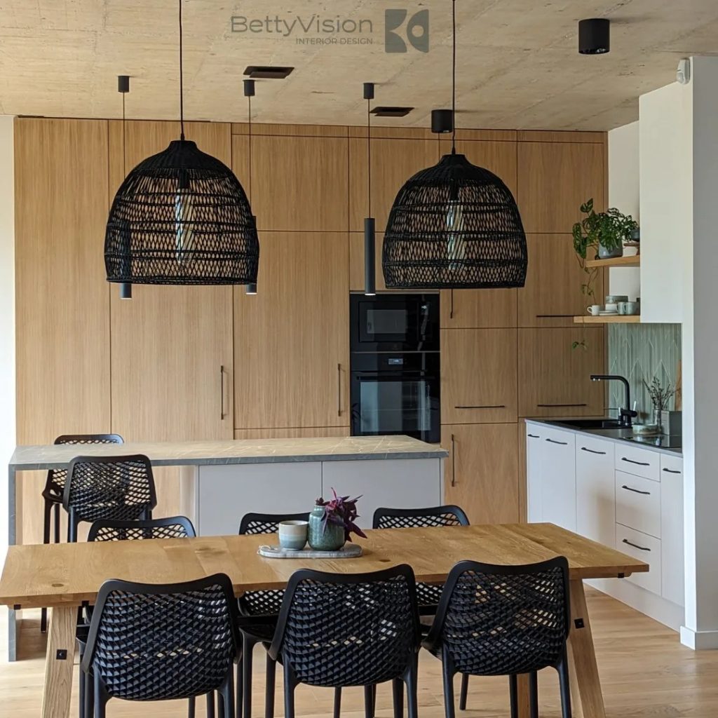 Wood-fronted kitchen and dining table beneath two oversized woven pendant lights.