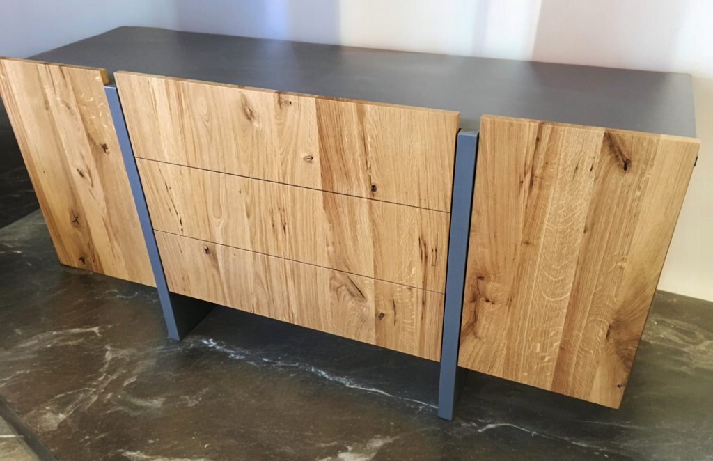 Freestanding wood sideboard with three drawers, doors and black metal frame.